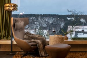 Rennsteig Chalet Toni Ferienhaus Thueringer Wald Wohnbereich mit Sessel und Blick in die winterliche Landschaft